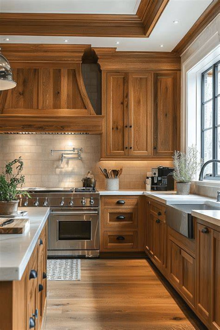 warm wood kitchen cabinets with plaster walls and neutral decor in organic modern kitchen design
